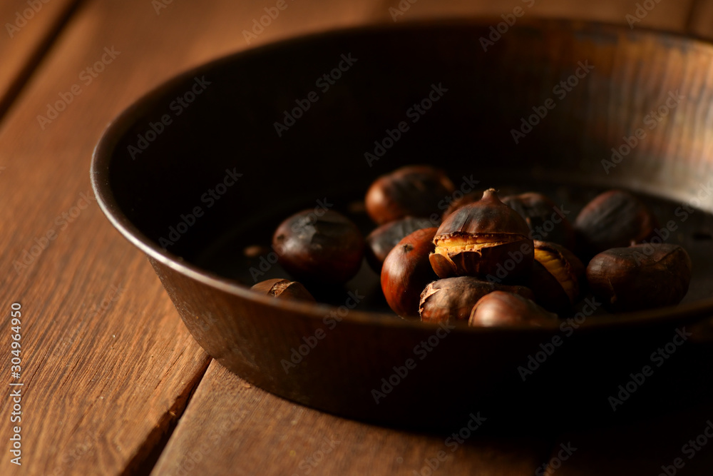 chestnuts in a pan on a wooden background