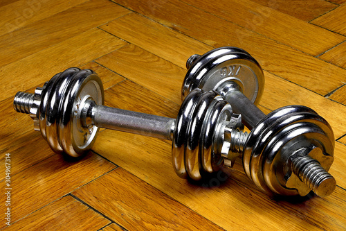 Close up of chrome dumbells on wooden floor