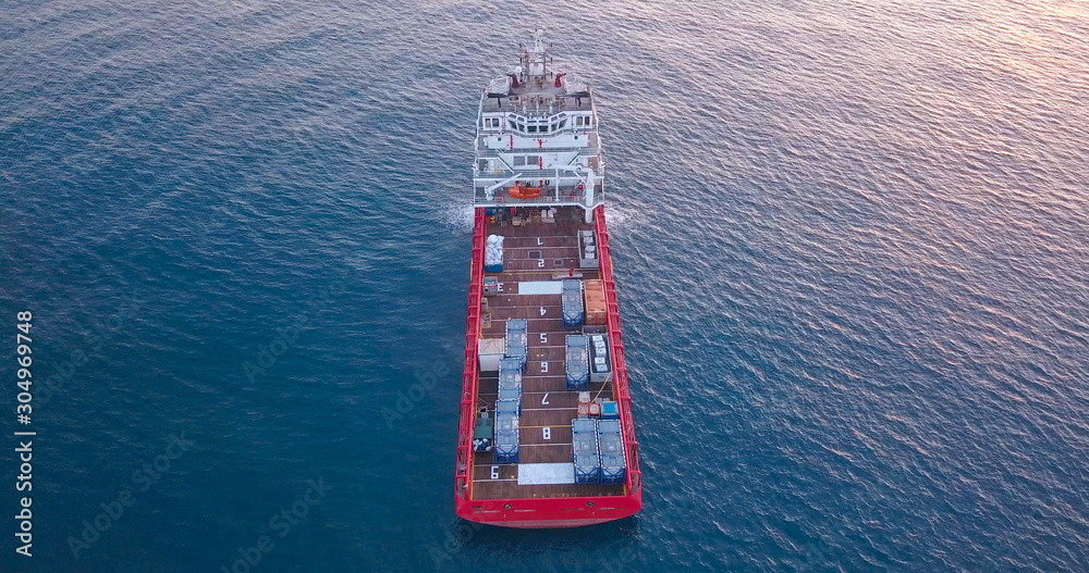 Aerial top view image of an Offshore Supply Ship in the calm ocean water.