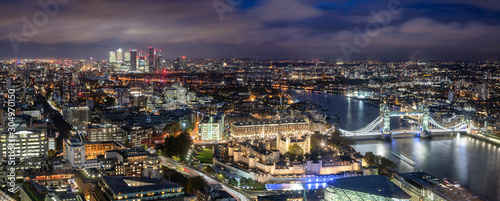 Luftaufnahme der Tower Brücke und des Towers von London am Abend mit dem Finanzbezirk Canary Wharf im Hintergrund, Großbritannien © moofushi