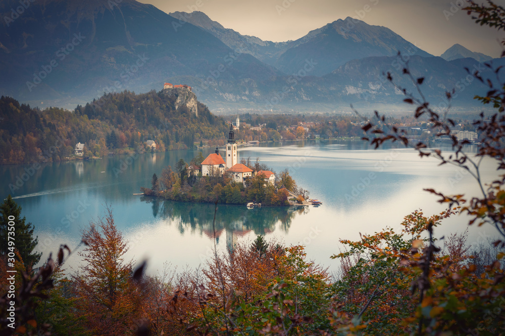 Bled lake with an island reflections framed by autumn colors of trees