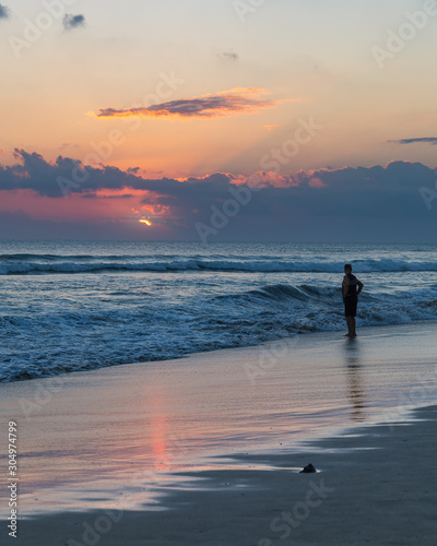 Beatiful sunset and silhouette of a man on Seminyak beach, Bali