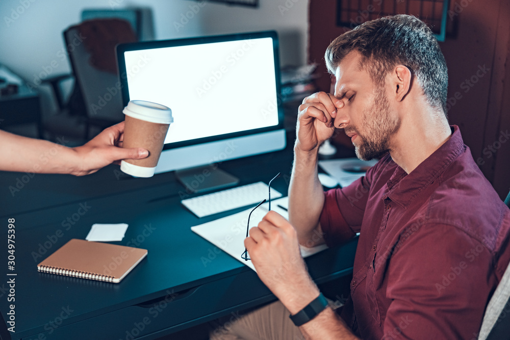Female assistant giving coffee to male employee Female assistant giving coffee to male employee