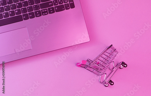 Online shopping concept. Laptop shopping trolley. Top view