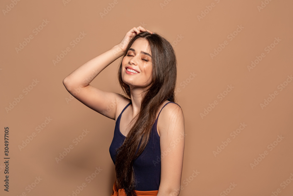 Freestyle. Young girl in top standing studio isolated on brown posing to camera closed eyes cheerful Freestyle. Young girl in top standing studio isolated on brown posing to camera closed eyes cheerful