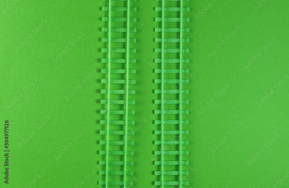 Toy railway rails on green background. Top view