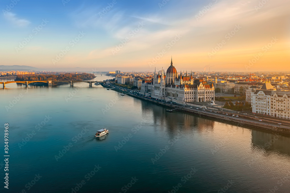 Obraz premium Nastrojowy poranek w Budapeszcie. Jeden statek płynie do węgierskiego budynku Parlaiment. Zwiedzanie, zdjęcie polecam do katalogów turystycznych, stron internetowych, czasopism.