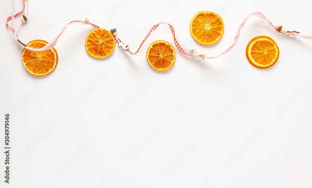 Naklejka Boże Narodzenie skład z suszonymi plasterkami pomarańczy na białym tle. Naturalny składnik suchej karmy do gotowania lub świątecznych dekoracji do domu. Leżał płasko.