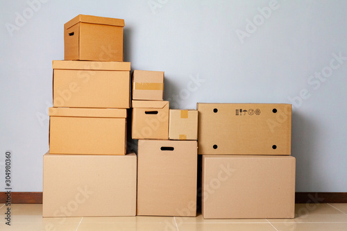Cardboard boxes for moving on the floor against grey wall © fotofabrika