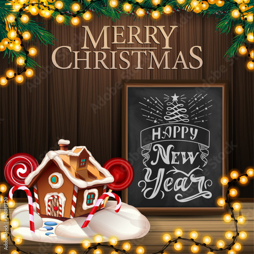 Merry Christmas and Happy New Year, square greeting postcard with wooden wall, garland, chalkboard with lettering and Christmas gingerbread house