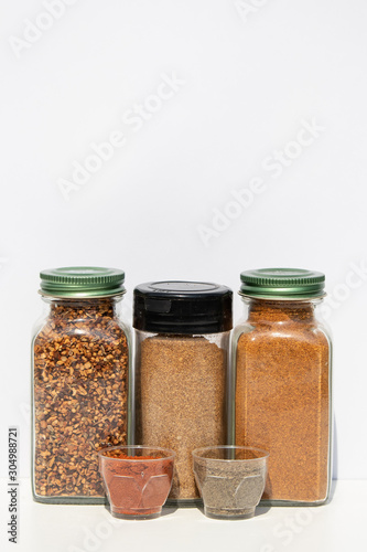 Three jars with spices of different grinding and two small bowls