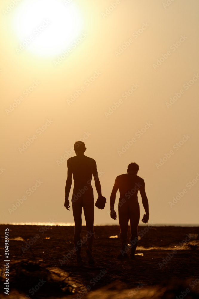 Nudists walk on the beach during sunset, Ada Bojana, Montenegro