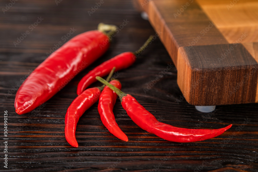 Chilli red pepper lie on wooden cutting board Chilli red pepper lie on wooden cutting board