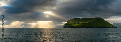 Beautiful rays of sun breaking through the clouds in Sandoy and Hestur ferry travel, Faroe Islands photo
