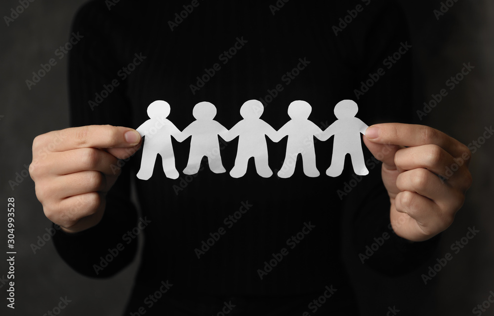 Woman holding paper people chain on grey background, closeup. Unity concept Woman holding paper people chain on grey background, closeup. Unity concept
