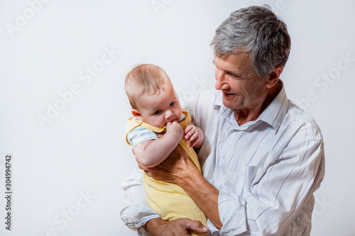 The grandfather and the baby. An old man holding his grandson in his arms