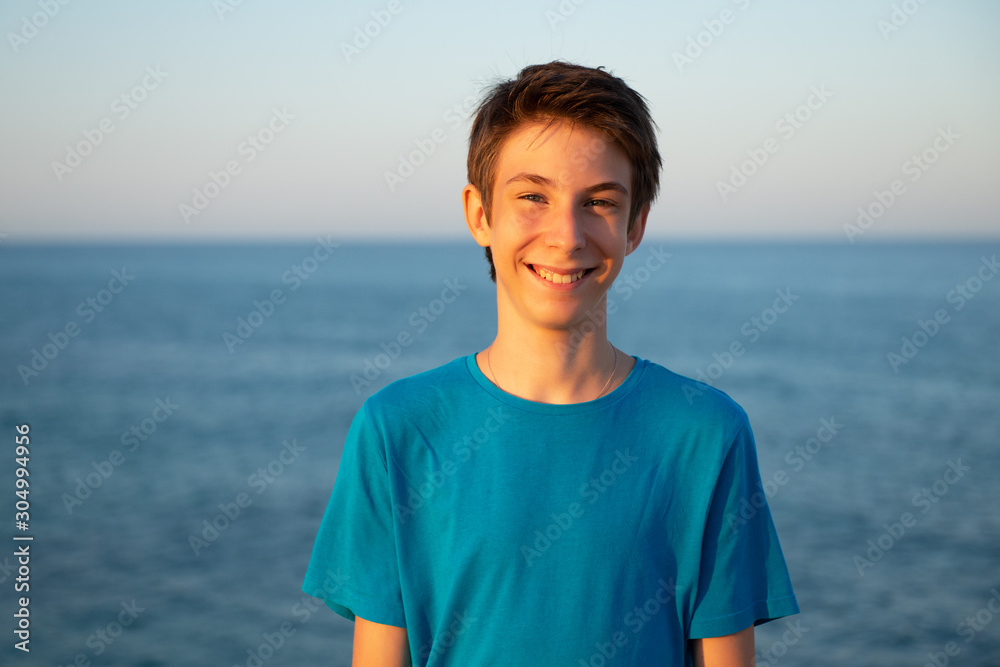 Handsome young boy at beach. Beautiful calm smiling teen boy at Mediterranean sea coast. Travel, summer vacation, tourism, teenage lifestyle. Handsome young boy at beach. Beautiful calm smiling teen boy at Mediterranean sea coast. Travel, summer vacation, tourism, teenage lifestyle.