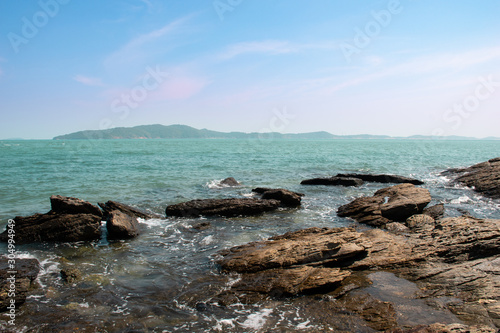 Fototapeta Naklejka Na Ścianę i Meble -  Rocky sea with splashing wave and far away one of the most famous island in Thailand.