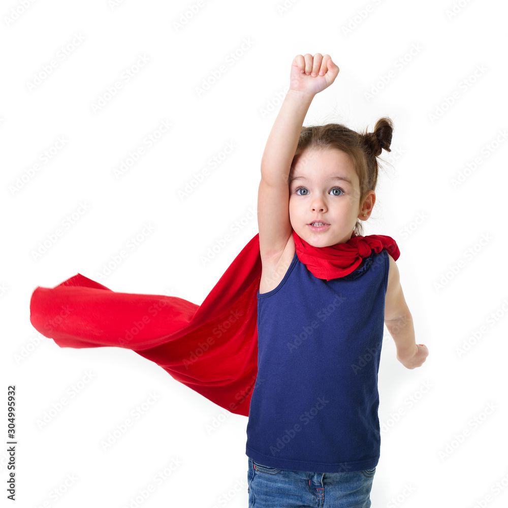 Adorable little girl flying like a superhero in blue t-shirt and red mantle. Super girl. The new generation saves the world. Good triumphs over evil. Funny kid portrait Adorable little girl flying like a superhero in blue t-shirt and red mantle. Super girl. The new generation saves the world. Good triumphs over evil. Funny kid portrait