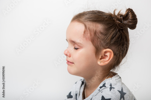 Crying little girl. Upset kid. Sad kid portrait. Cute little gilr crying and does not want to go in bed at night