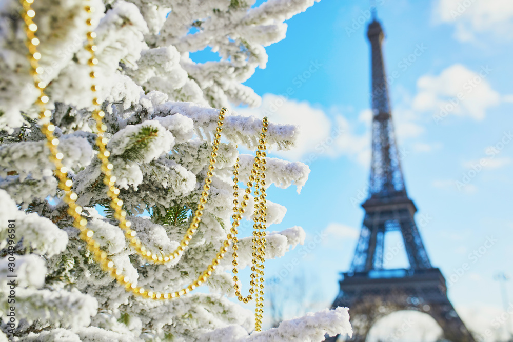 Christmas tree covered with snow near the Eiffel tower Christmas tree covered with snow near the Eiffel tower