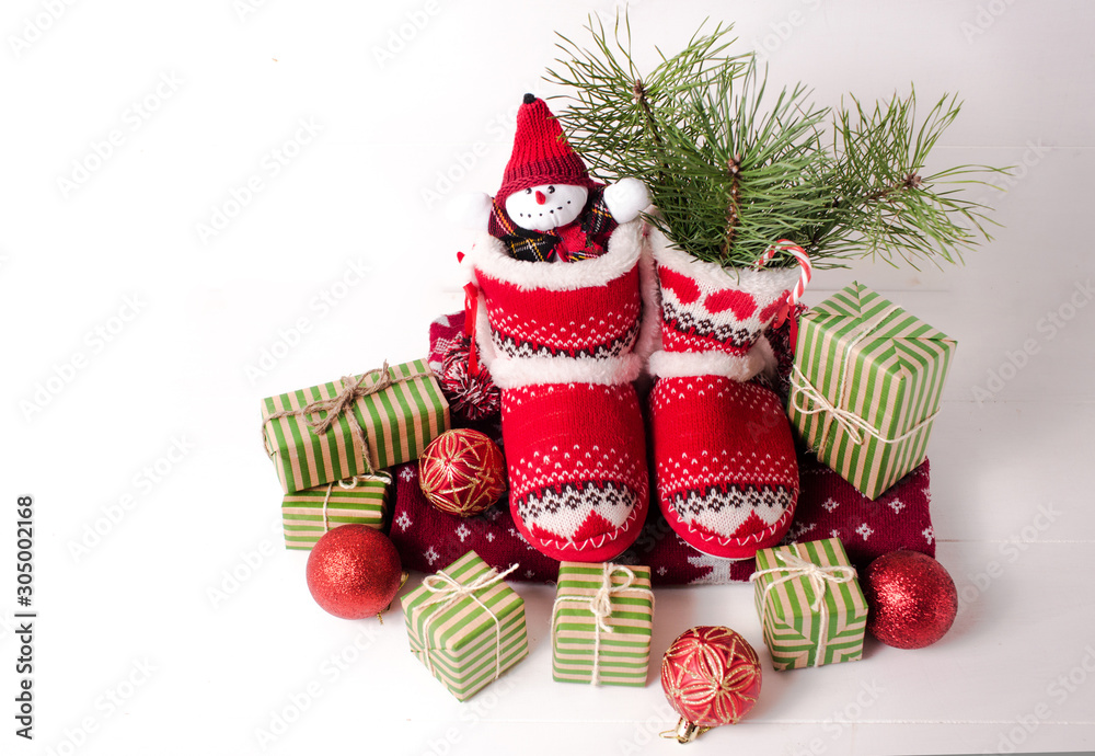 Little knitted boots with Christmas gifts and various decorations