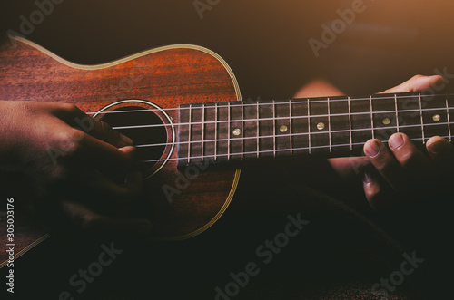 Hands playing acoustic ukulele guitar.Music skills show