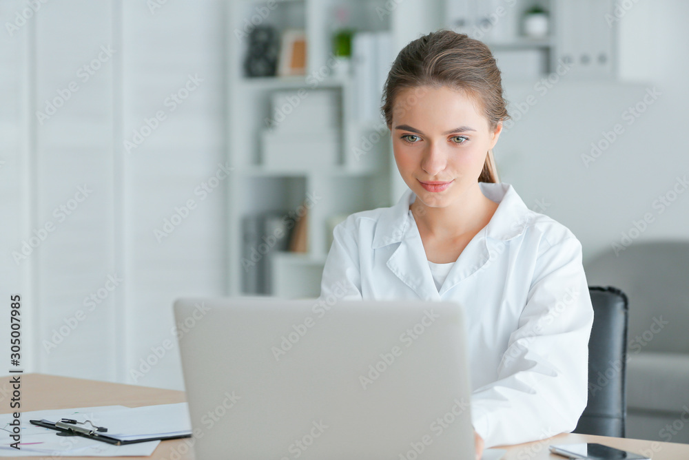 Female doctor working on laptop in clinic Female doctor working on laptop in clinic