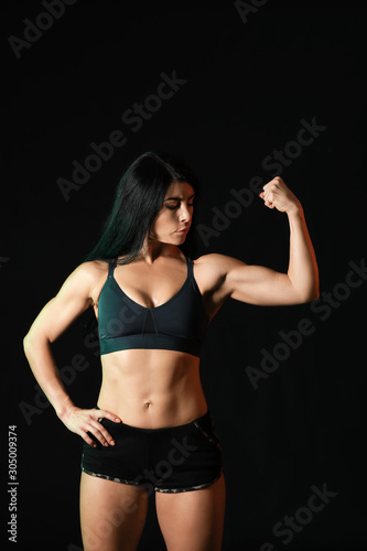 Sporty muscular woman on dark background © Pixel-Shot