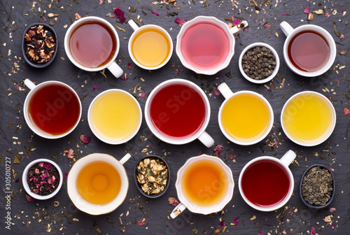  Assortment of tea cups on dark, stone background, top view