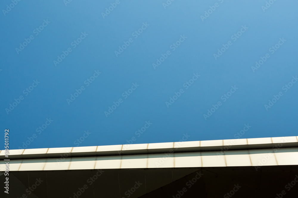 The edge of building roof and the copy space on clear blue sky