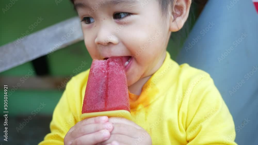 Portrait of a happy smiling Asian child girl and enjoy eating icecream outdoors. Portrait of a happy smiling Asian child girl and enjoy eating icecream outdoors.