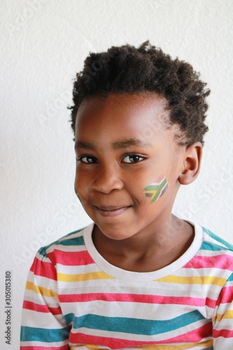 young african child with afro and face paint of the south african flag