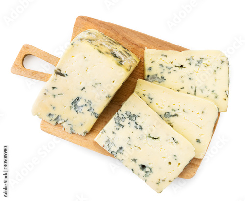 Cheese with mold cut into pieces on a wooden board, on a white background. The view of top.