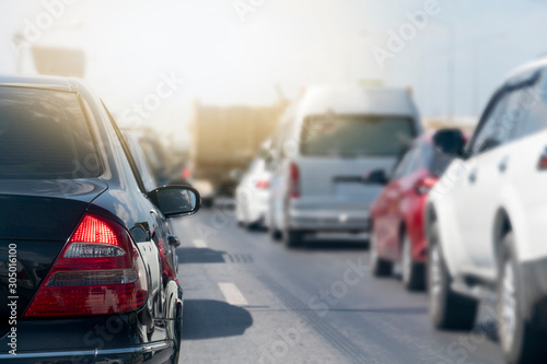 Black car and other cars stop on asphalt road. Traffic jam during rush hour. Keep connecting in various lenses orderly. And bright light.