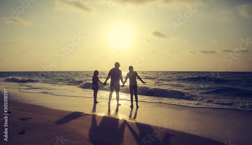 Father with two kids enjoying summer vacation on the beach