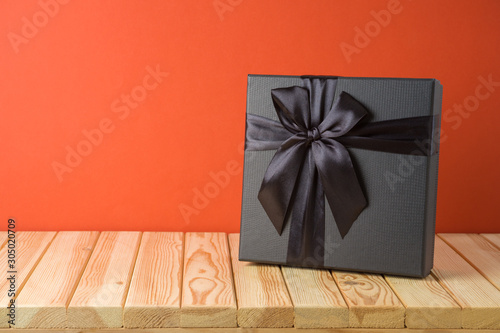 Black Friday sale concept with gift box on wooden table photo