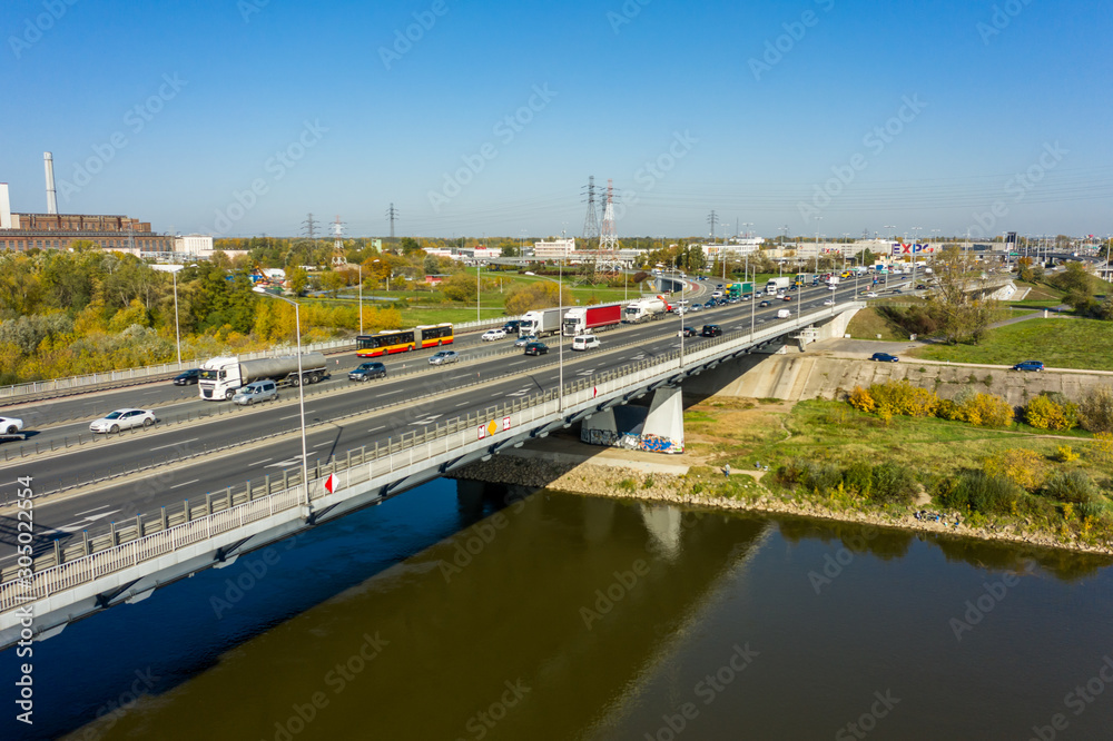 Aerial view of traffic jams on an automobile bridge with many vans and cars. Highway passes through the river and leads to the center of Warsaw, Poland. 