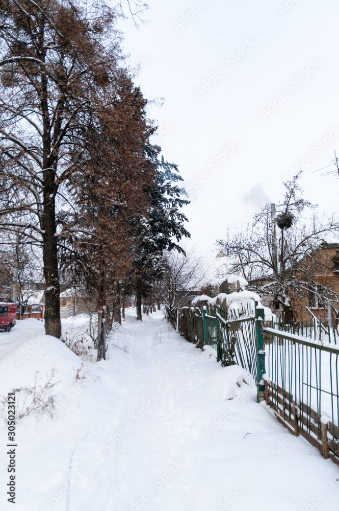 Naklejka premium Snow covered courtyard in the village. Snowy street.