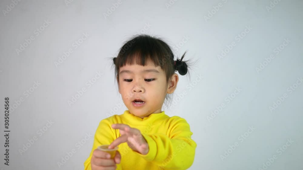 Portrait of a happy smiling Asian child girl and enjoy eating jelly isolated on white background.