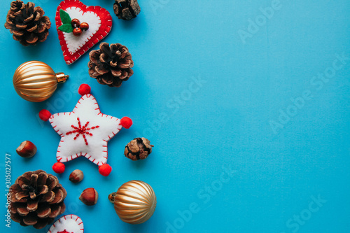 Copyspace flat lay of Soft felt toys like stars, hearts and pine cones on the blue background. New year backgrounds concept. Festive christmas flatlays of decorations concept.
