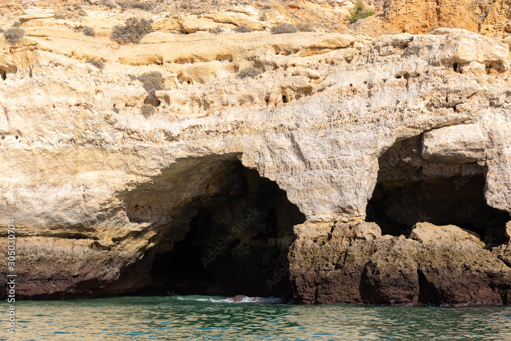 Landscape with sandstone cave off the Algarve coast in Portugal
