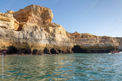 Beautiful landscape of Algarve, Portugal coast with sandstone cliffs, beach and ocean under cloudless blue sky  © Isabelle
