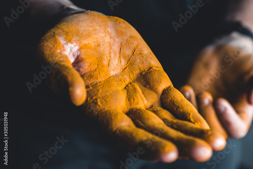 Turmeric in hand With black background. medicine. food supplement.
