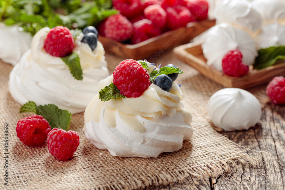 Dessert Pavlova with raspberries, blueberries and mint on a old wooden table. Dessert Pavlova with raspberries, blueberries and mint on a old wooden table.