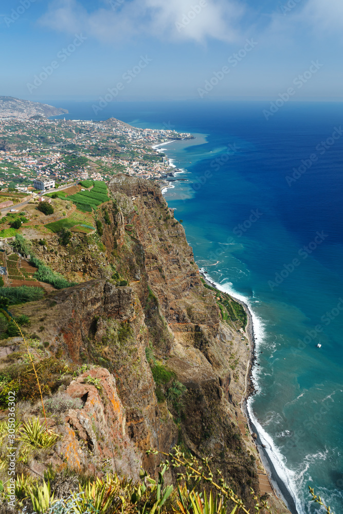 amazing view from the highest Cabo Girao cliff on the beach, ocean water and Camara de Lobos town, Madeira island, Portugal
