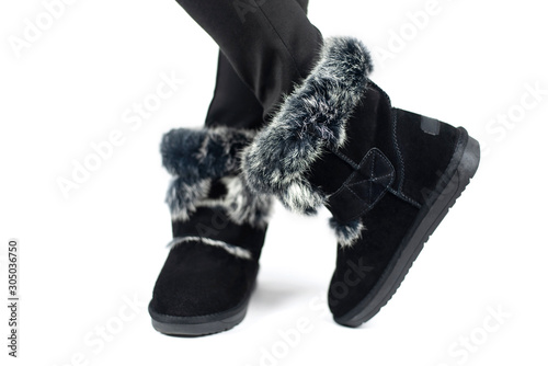 Winter black shoes in uggy style with gray fur on a white background with light shadow photo