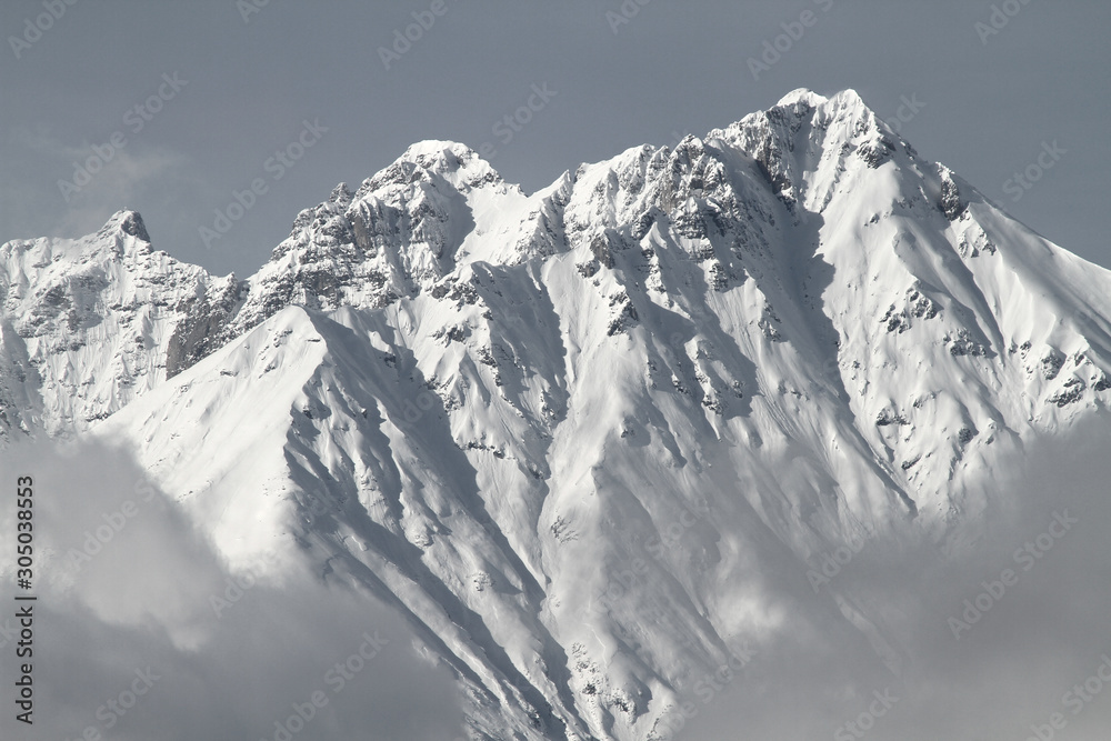 Blick von Innsbruck im Inntal in Tirol auf die Nordkette und die schneebedeckten Gipfel im Winter. Lawinengefahr