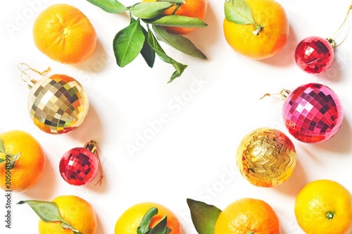 Fototapeta Naklejka Na Ścianę i Meble -  Flat lay citrus frame, view from above photography. Christmas fruit food, sweet dessert. Chinese New Year celebration. Fresh juicy mandarins with leaves and golden, red decorative balls