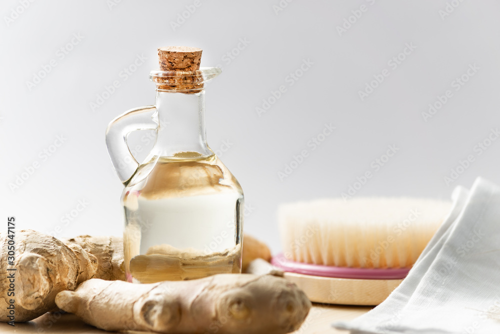 Ginger, body brush and ginger oil on light background. Ginger, body brush and ginger oil on light background.
